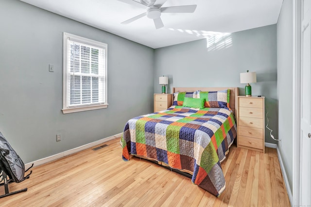 bedroom featuring visible vents, ceiling fan, baseboards, and hardwood / wood-style flooring