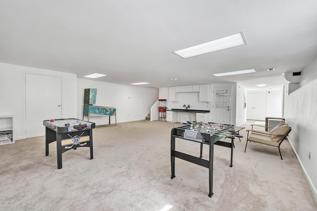 game room with baseboards and light carpet