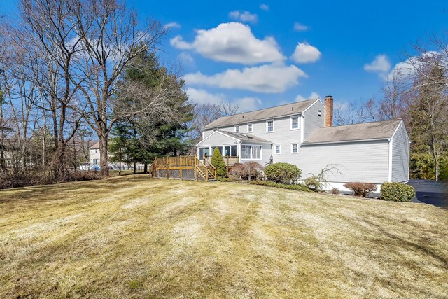 back of house featuring stairs, a wooden deck, a yard, and a chimney