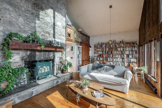 living area featuring baseboard heating, high vaulted ceiling, and light wood-style floors