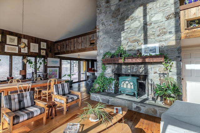 living area featuring wood walls, high vaulted ceiling, and hardwood / wood-style flooring