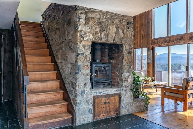 staircase featuring a mountain view, a textured ceiling, and a wood stove