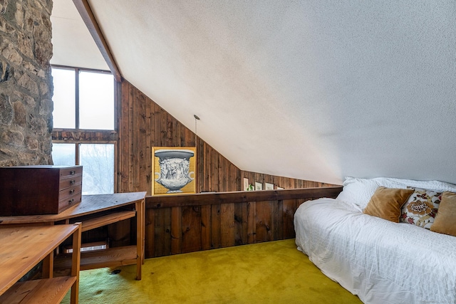 bedroom with carpet floors, a textured ceiling, wood walls, and vaulted ceiling with beams