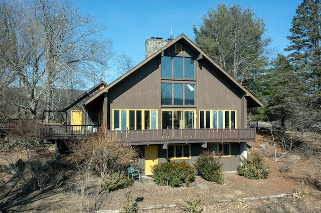 back of property featuring a wooden deck and a chimney