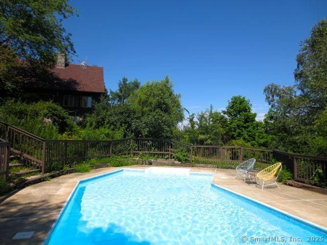 view of swimming pool with a patio, a fenced in pool, and fence