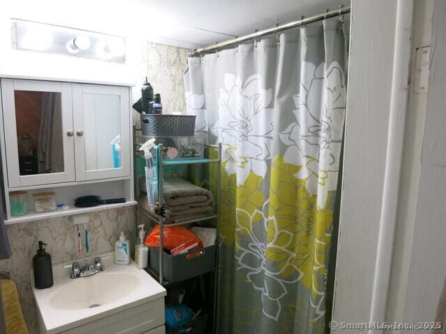 bathroom with vanity, a shower with shower curtain, and tasteful backsplash