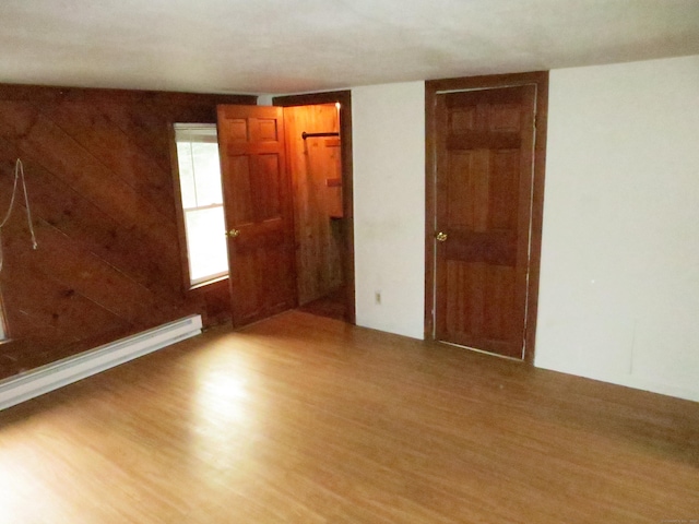 interior space featuring a baseboard heating unit and light wood finished floors