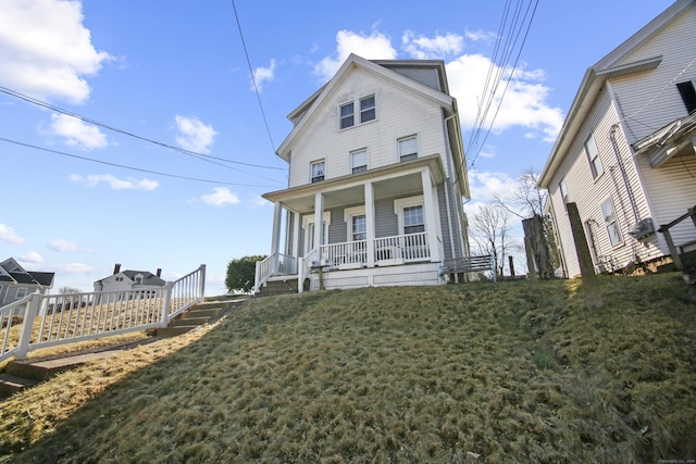 view of front of house with covered porch and a front lawn