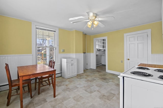 kitchen featuring electric range, wainscoting, and ceiling fan