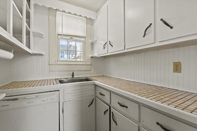 kitchen featuring a sink, white cabinetry, white dishwasher, light countertops, and glass insert cabinets