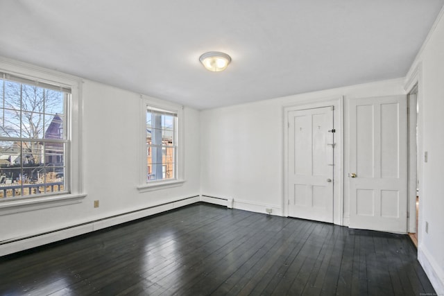 unfurnished bedroom featuring a baseboard heating unit, multiple windows, dark wood-style floors, and baseboards