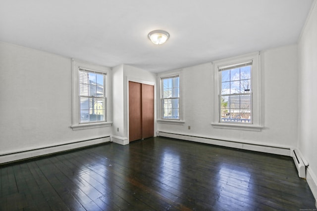 spare room with dark wood-style floors, plenty of natural light, and a baseboard radiator