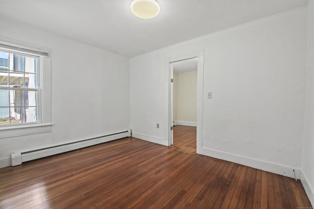 unfurnished room with a baseboard heating unit, baseboards, and dark wood-style flooring