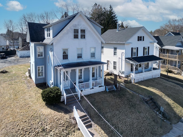 rear view of house with a porch and a shingled roof