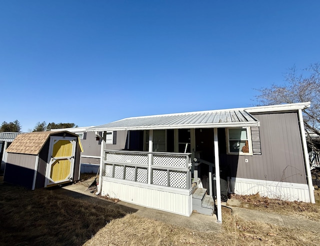 manufactured / mobile home featuring a storage unit, a porch, and an outdoor structure