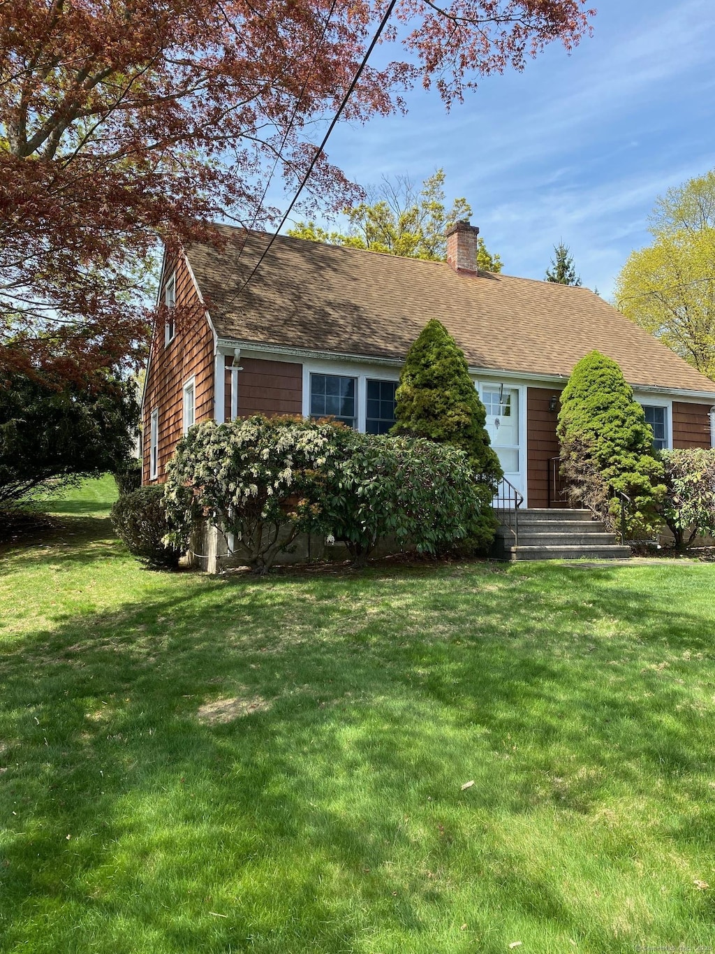411 Wormwood Rd, Fairfield, CT 06824 - single story home featuring a front yard, a shingled roof, and a chimney