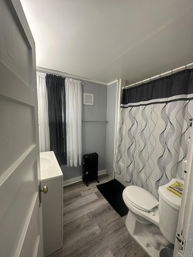 bathroom with vanity, radiator, wood finished floors, visible vents, and toilet