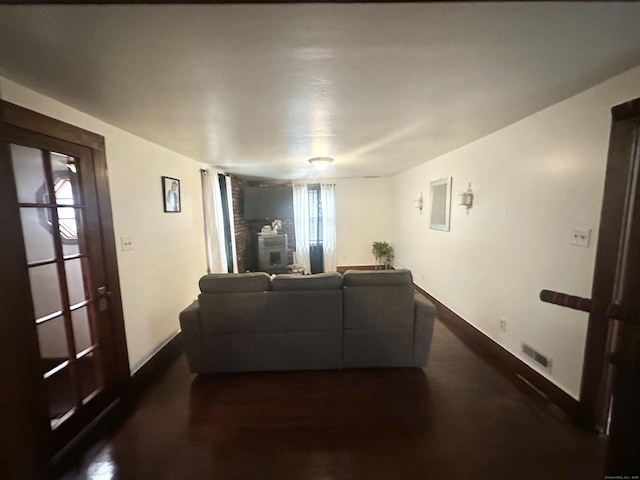 living room with baseboards, visible vents, and dark wood-style flooring