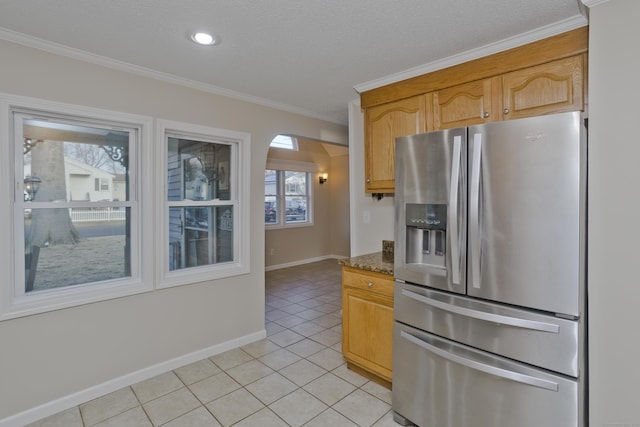 kitchen featuring crown molding, baseboards, stainless steel fridge with ice dispenser, light tile patterned floors, and arched walkways