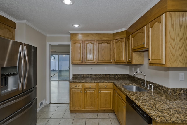 kitchen with visible vents, ornamental molding, dark stone countertops, appliances with stainless steel finishes, and a sink