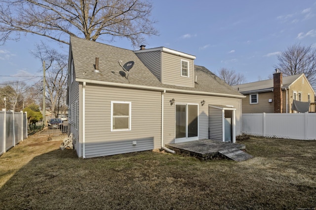 rear view of house featuring a fenced backyard and a yard