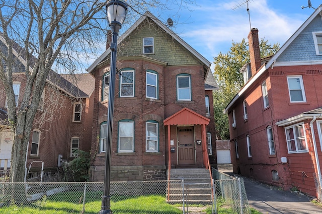 view of front of property featuring brick siding and a fenced front yard