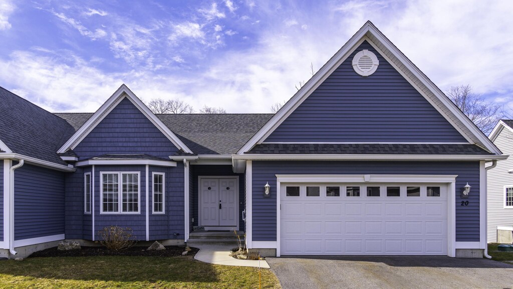 single story home with aphalt driveway, an attached garage, and a shingled roof
