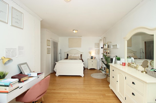 bedroom with light wood-style floors and ornamental molding