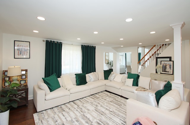 living room featuring stairway, recessed lighting, wood finished floors, and decorative columns