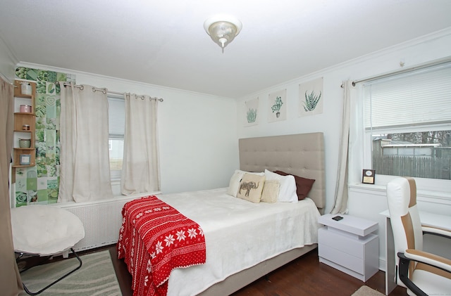 bedroom with radiator, wood finished floors, and ornamental molding