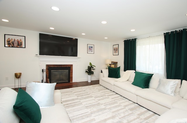 living area with a fireplace, wood finished floors, recessed lighting, and baseboards
