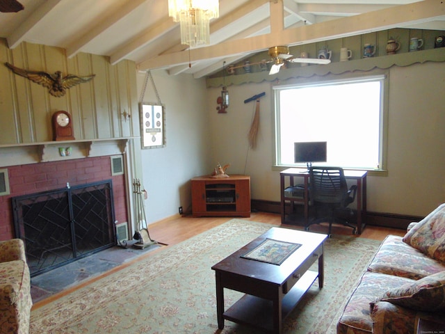 living area with lofted ceiling with beams, a brick fireplace, ceiling fan, and light wood finished floors