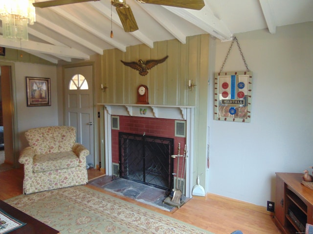 living room featuring visible vents, a brick fireplace, vaulted ceiling with beams, ceiling fan, and wood finished floors