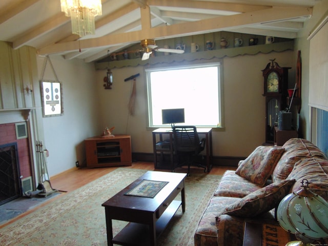 living area with wood finished floors, baseboards, a ceiling fan, vaulted ceiling with beams, and a fireplace