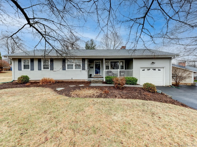 single story home featuring a front yard, covered porch, a chimney, driveway, and an attached garage