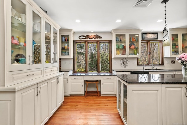 135 Wildwood Dr, Stratford, CT 06614 - kitchen with dark stone counters, hanging light fixtures, a sink, light wood-style floors, and visible vents