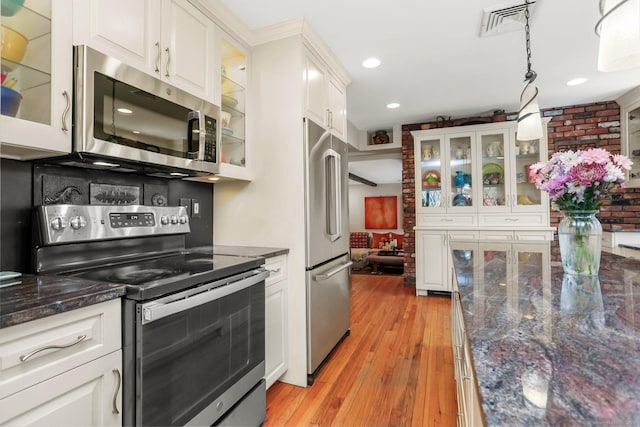 135 Wildwood Dr, Stratford, CT 06614 - kitchen with white cabinets, visible vents, light wood-type flooring, glass insert cabinets, and appliances with stainless steel finishes