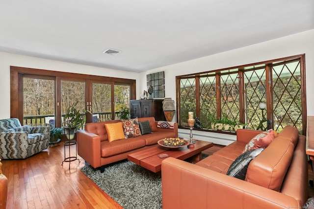 135 Wildwood Dr, Stratford, CT 06614 - living room with hardwood / wood-style floors, visible vents, and a baseboard radiator