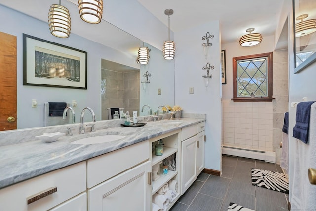 135 Wildwood Dr, Stratford, CT 06614 - full bathroom with a baseboard radiator, double vanity, tile walls, and a sink