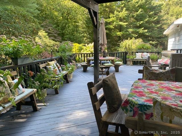 135 Wildwood Dr, Stratford, CT 06614 - wooden terrace with outdoor dining area and a view of trees