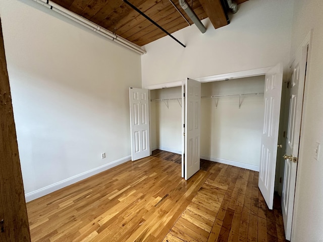 145 Canal St Unit 104, Shelton, CT 06484 - unfurnished bedroom with a wood ceiling with exposed beams, light wood-style flooring, and a towering ceiling