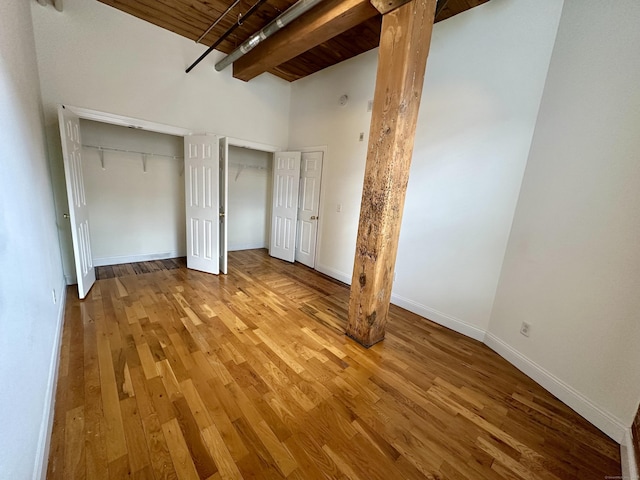 145 Canal St Unit 104, Shelton, CT 06484 - unfurnished bedroom featuring wood finished floors, a wood ceiling with exposed beams, and a high ceiling