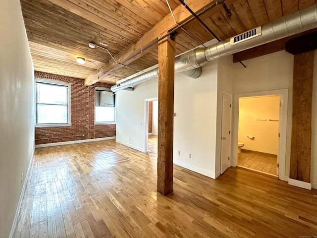 145 Canal St Unit 104, Shelton, CT 06484 - unfurnished living room with hardwood / wood-style flooring, wooden ceiling, and brick wall
