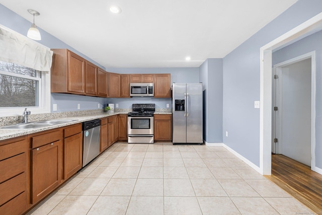 kitchen with light countertops, brown cabinets, a sink, and stainless steel appliances