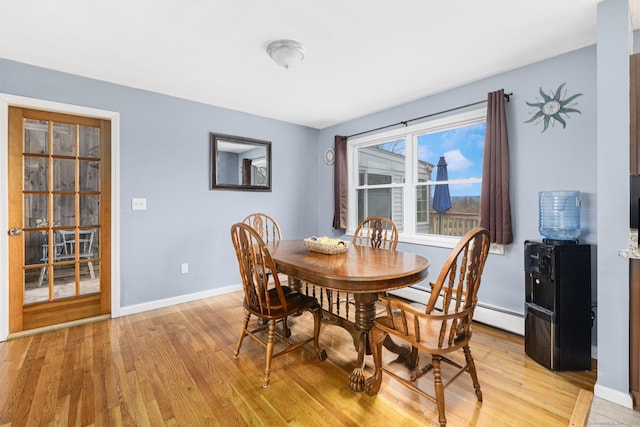 dining space with light wood-style flooring, baseboards, and baseboard heating