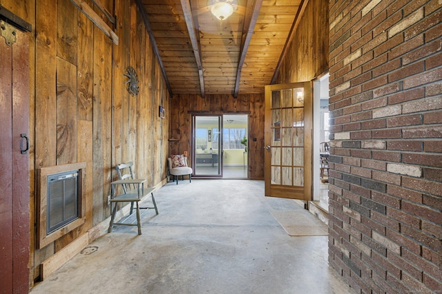 interior space featuring lofted ceiling with beams, unfinished concrete floors, wood ceiling, wooden walls, and heating unit