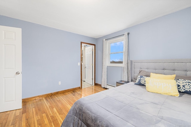 bedroom with baseboards and wood finished floors