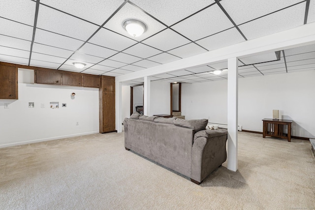 living room featuring a paneled ceiling, light colored carpet, and baseboards