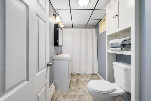 full bath featuring curtained shower, vanity, a drop ceiling, and toilet