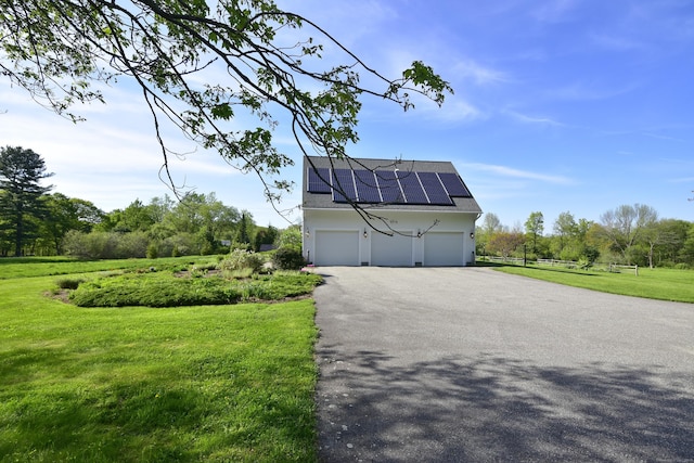 40 Shields Rd, Woodstock, CT 06281 - view of side of property with driveway, roof mounted solar panels, a lawn, stucco siding, and a garage